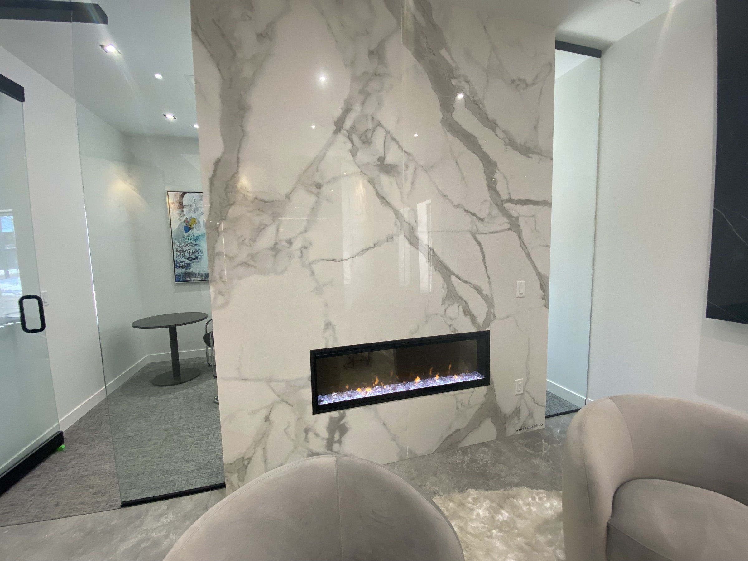 Floor to ceiling Calacatta look slab fireplace surround with linear fireplace insert