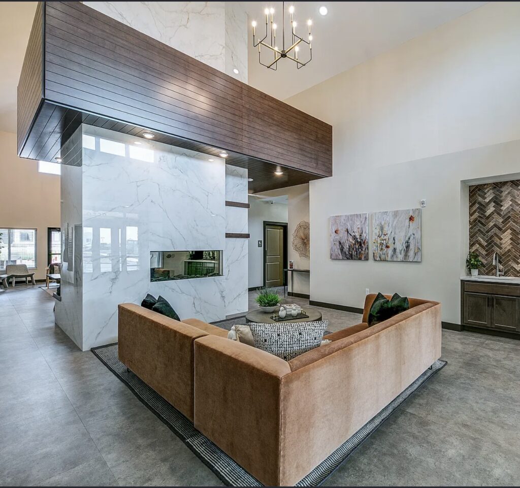 Double sided stone fireplace feature anchoring a commercial lounge