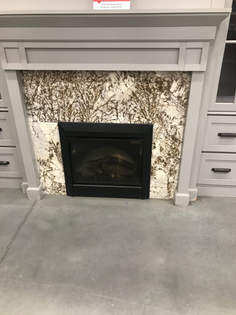 Granite fireplace surround display with painted mantel in the Leon's Countertops showroom